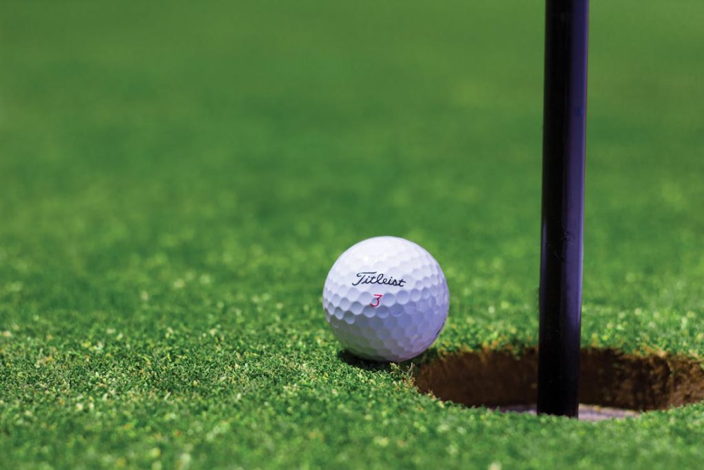 Golf ball resting near the hole during a tournament hole-in-one contest