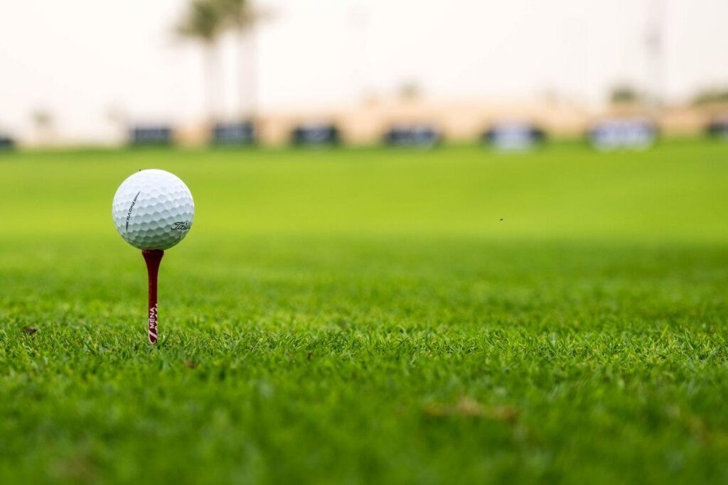 Golf ball on a tee during a charity golf event featuring an insured hole-in-one prize contest.