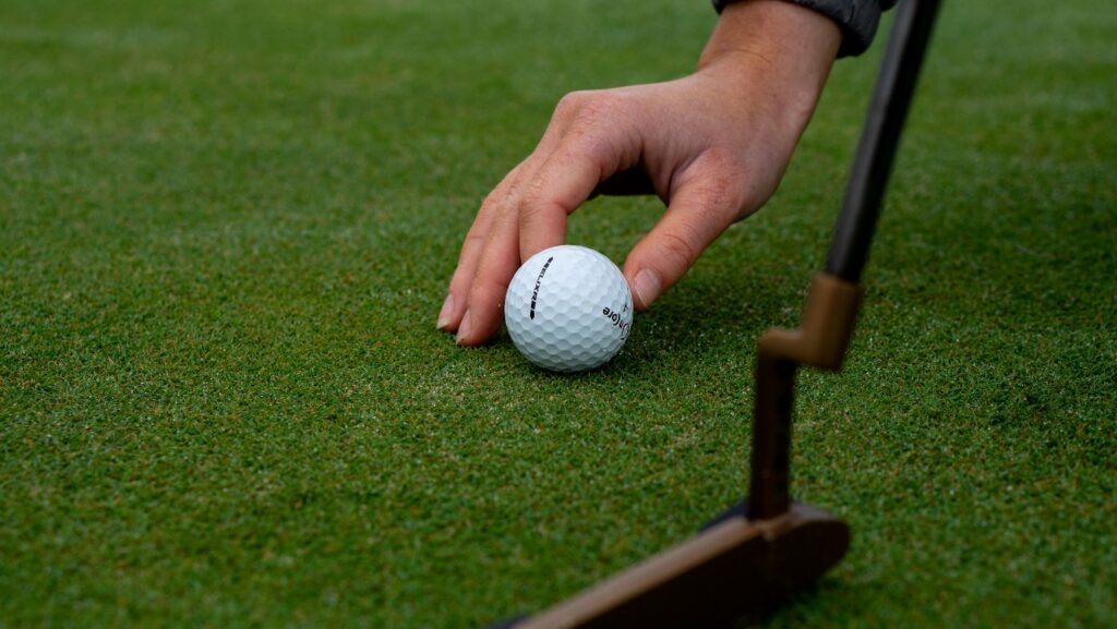 A person holding a golf ball