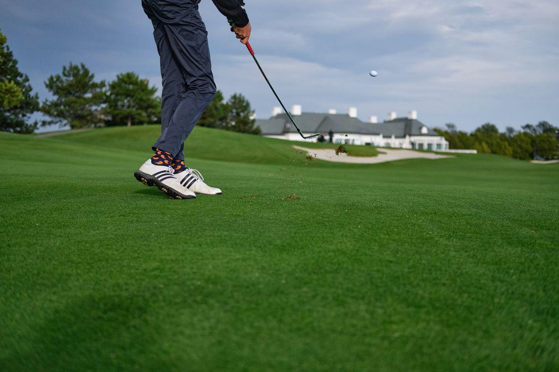 Golfer taking a shot during a tournament supported by hole-in-one contest insurance and prize promotions.
