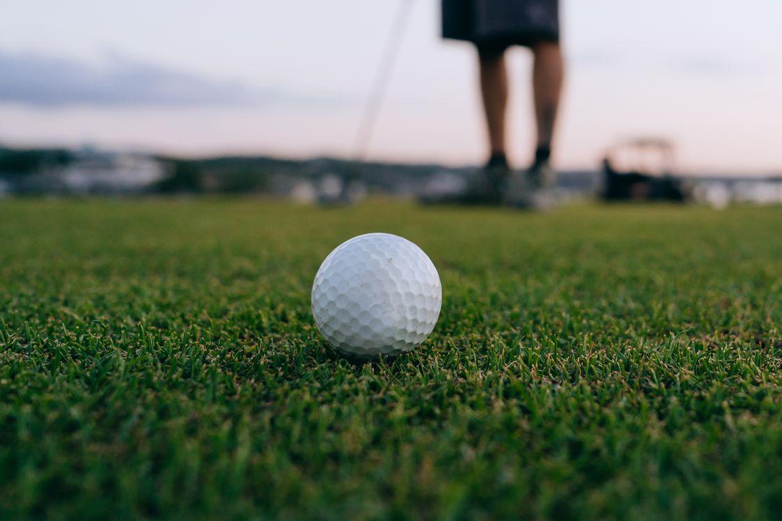 Golf ball on a course highlighting the benefits of a hole-in-one prize package insurance for tournament events.