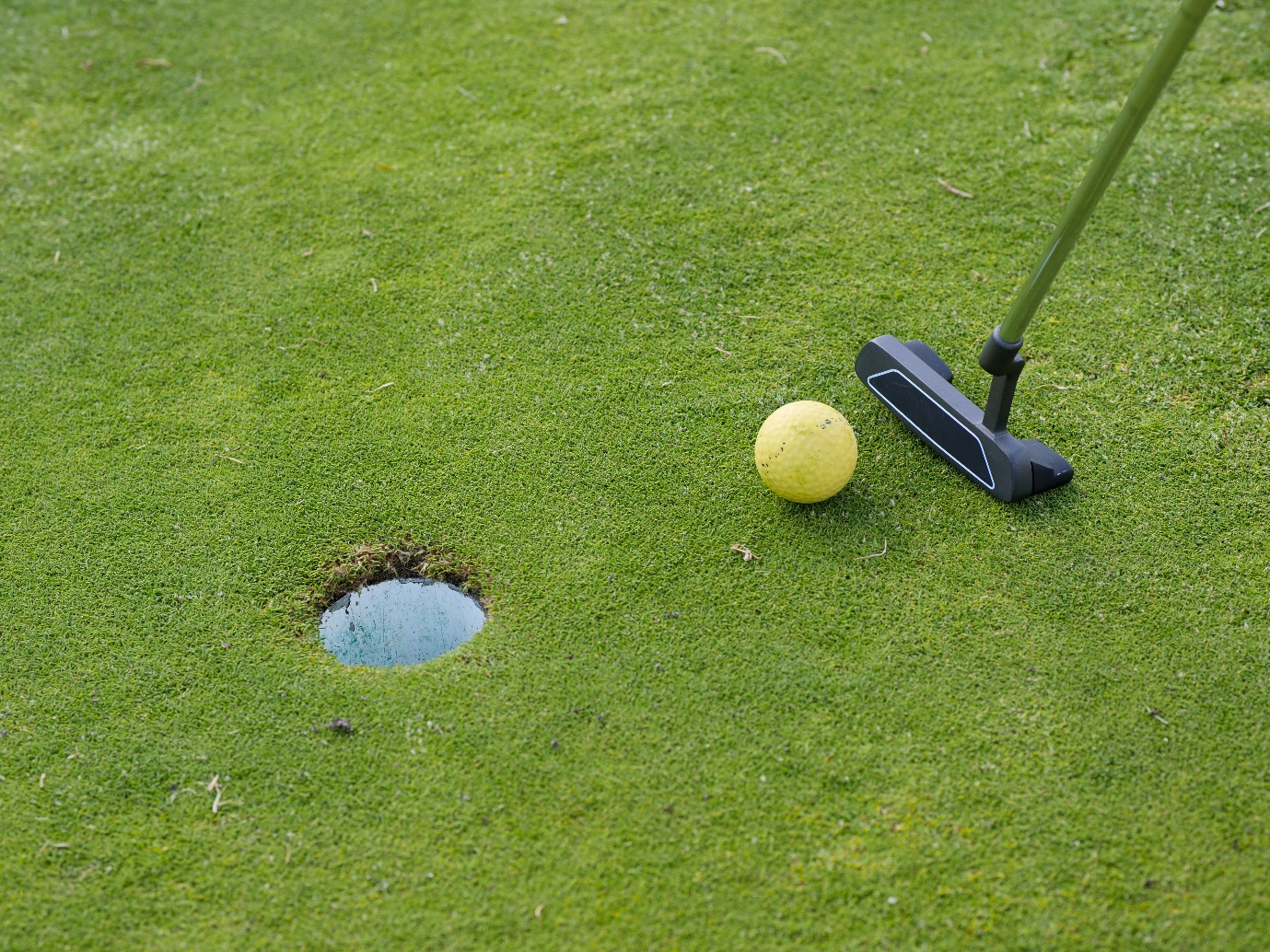A golf ball near a hole