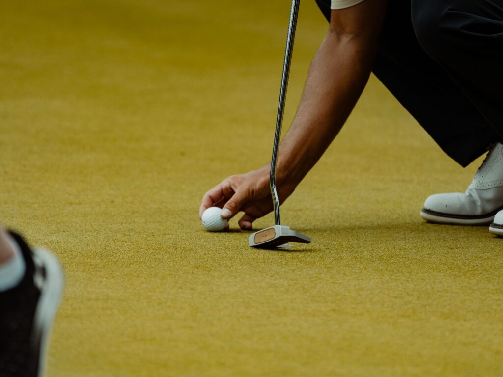 A person placing a golf ball