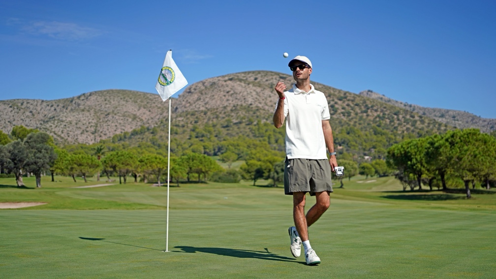 Golfer beside prize hole
