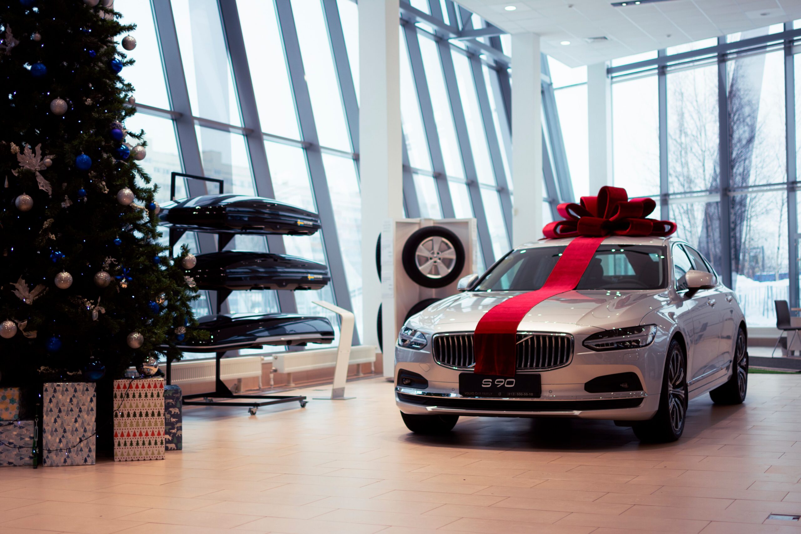 Red gift ribbon wrapped around a car