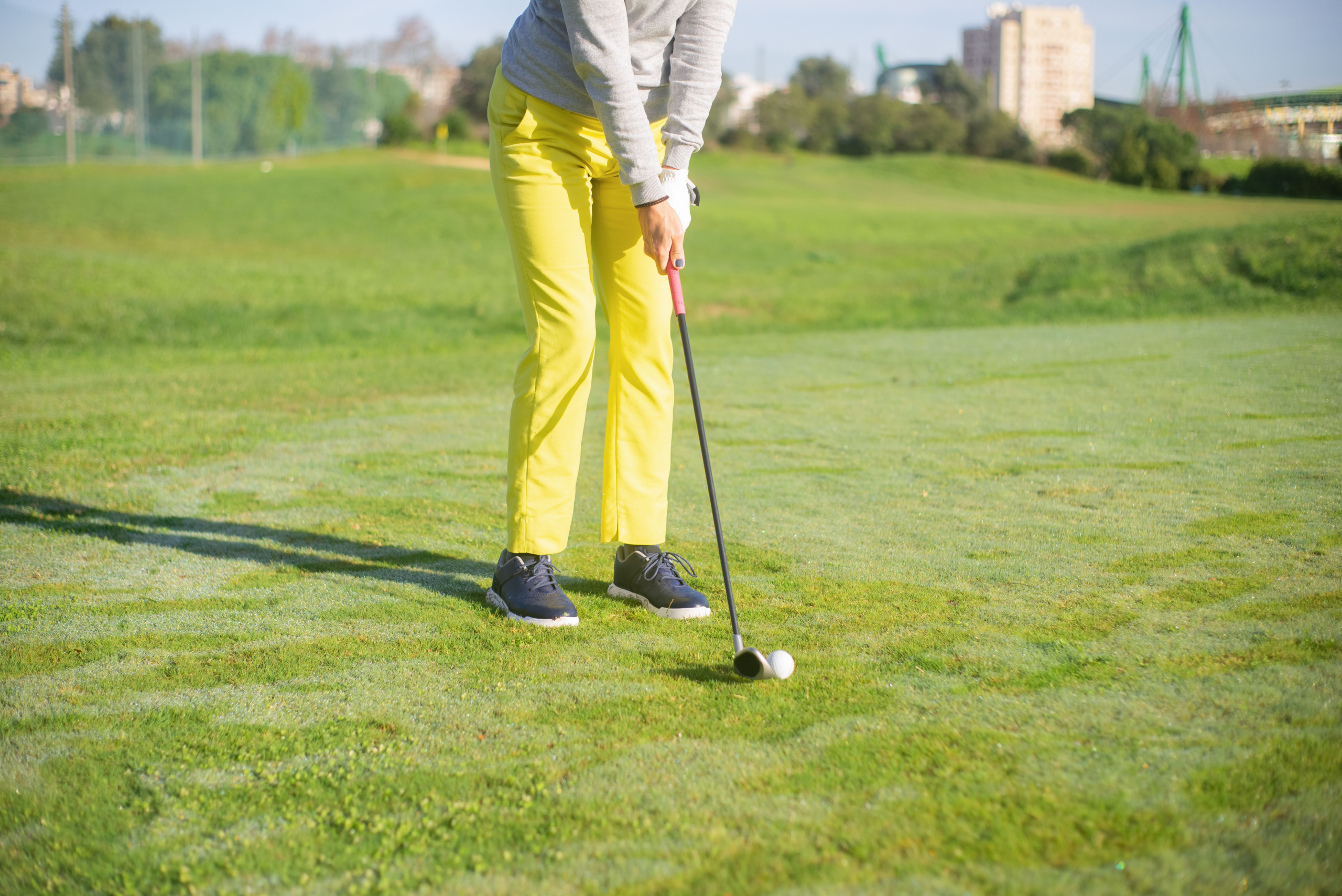 Person in yellow pants holding a golf club