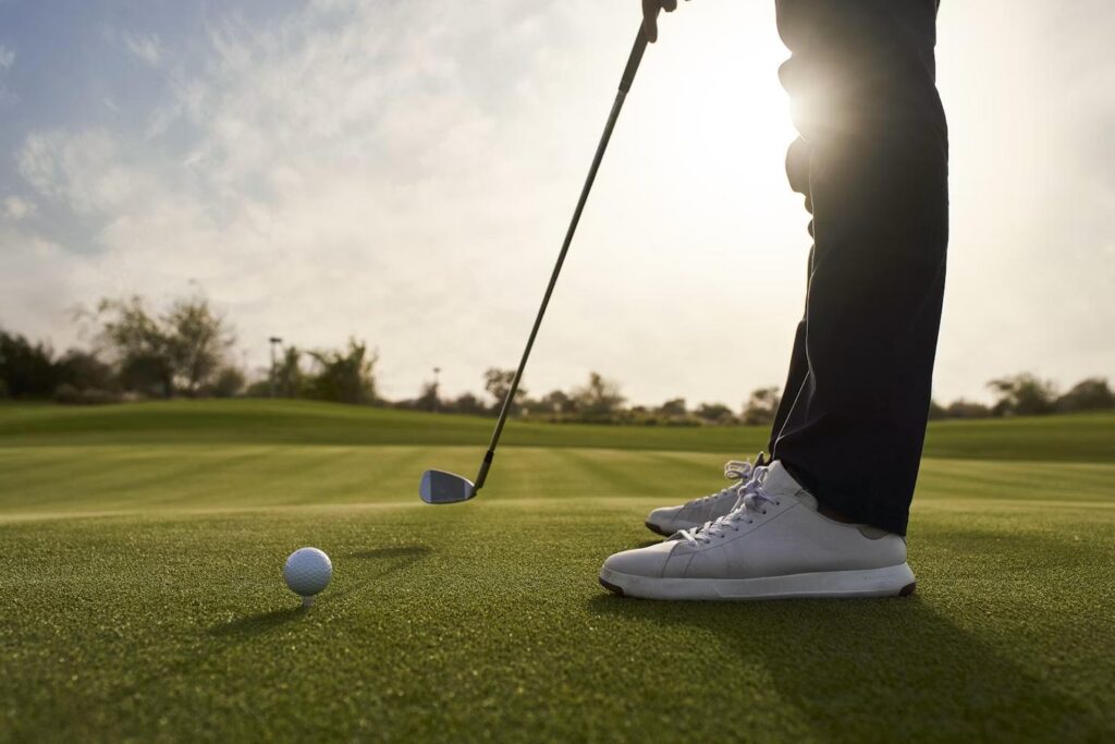 Golfer preparing to putt on a green representing the process of choosing a reliable hole-in-one insurance company.