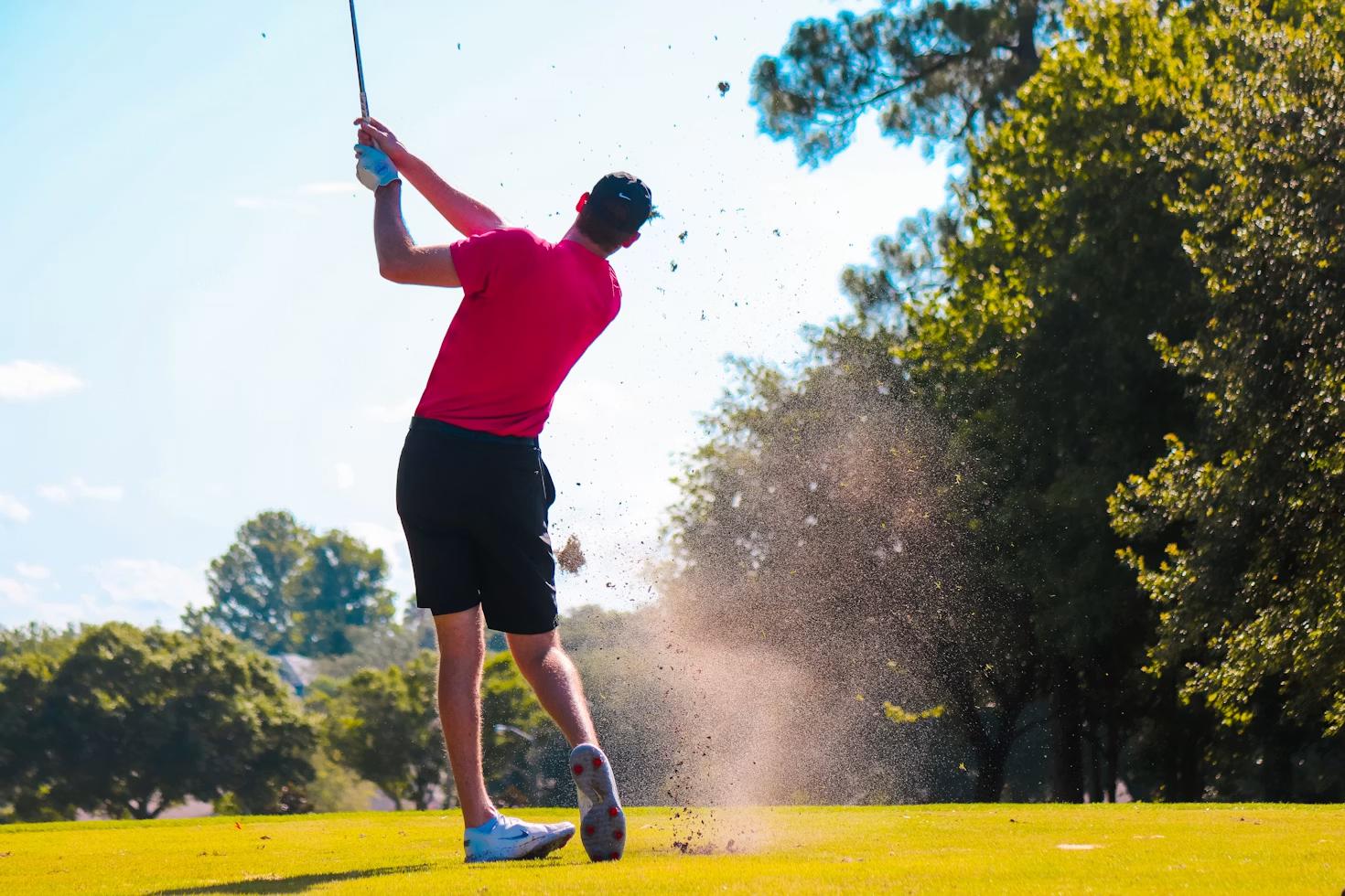Golfer hitting a tee shot during a tournament with multiple insured hole-in-one prize holes across the course.